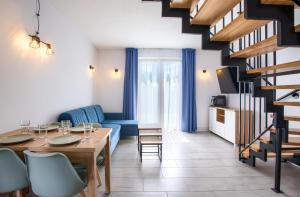a living room with a table and a blue couch at Domki Venus z basenem in Ustronie Morskie