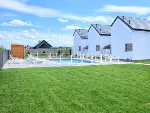 a house with a yard with a swimming pool at Domki Venus z basenem in Ustronie Morskie