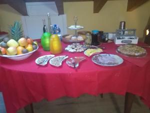 een tafel met een rode tafeldoek met eten erop bij B&B Paradiso in Negrar