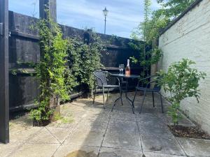 a patio with a table and chairs in a backyard at The Old King Bill in Fenstanton