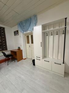 ein Zimmer mit einem weißen Kleiderschrank und einem Schreibtisch in der Unterkunft Arnas in Barskoon