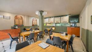 a dining room with wooden tables and chairs at Sumitel Premier Inn in Siliguri