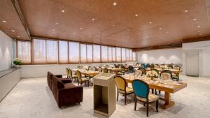 a large dining room with tables and chairs at Sumitel Premier Inn in Siliguri +3 photos