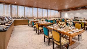 a dining room with tables and chairs in a room at Sumitel Premier Inn in Siliguri
