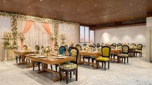 a dining room with wooden tables and chairs at Sumitel Premier Inn in Siliguri