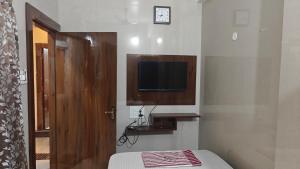 a bedroom with a bed and a tv on the wall at Sasi Residency in Thiruchendur