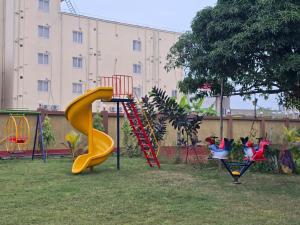 a playground with a yellow slide in a yard at RESORT SAIKAT SARANYA in Mandarmoni