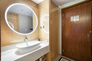 a bathroom with a sink and a mirror at Ibis Styles Liyang Shanghecheng in Liyang +17 photos