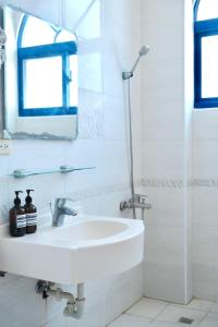 a white bathroom with a sink and a shower at Island River in Green Island +52 photos