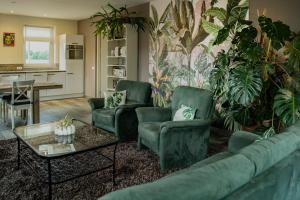 a living room with a couch and chairs and a table at Het Atelier Huis - Geschikt tot 8 personen in Maasbommel