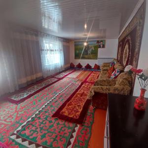 a living room with a couch and a rug at Kamas Guesthouse in Kyzart