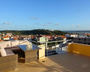 a balcony with a table and a view of a city at Casa Lagoa Azul in Foz do Arelho