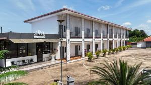 a large white building with a parking lot at DD Grand Hotel in Seka