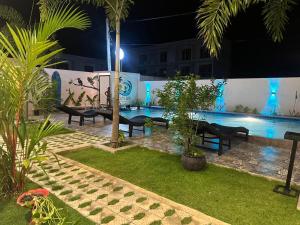 a swimming pool at night with benches and trees at Cozy Bay Hotel in Arugam Bay