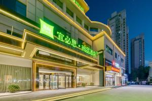 a building with neon signs on the side of it at Ibis Styles Liyang Shanghecheng in Liyang