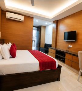 a hotel room with a bed and a flat screen tv at Hotel Good Will Residency - DLF Cyber City Gurgaon in Gurgaon