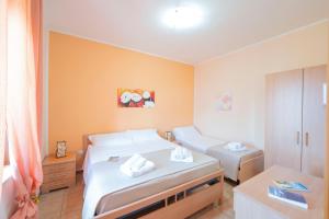 a hotel room with two beds and a table at Casette nel Borgo in Borgagne