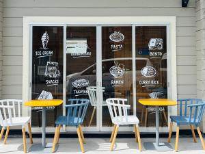 a store with three tables and chairs in front of a window at インザ富士 in Fujiyoshida