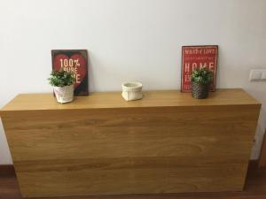 a wooden dresser with two plants on top of it at Apartamento FIRA Barcelona in Hospitalet de Llobregat