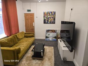 a living room with a couch and a flat screen tv at J & T property in Great Coates