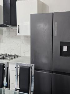 a kitchen with a stainless steel refrigerator and a stove at J & T property in Great Coates