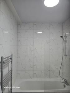 a bathroom with a shower and a bath tub at J & T property in Great Coates
