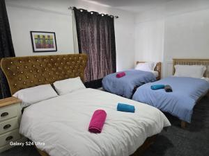 a bedroom with two beds with towels on them at J & T property in Great Coates