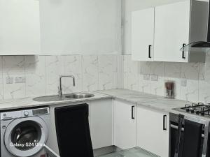 a kitchen with a sink and a washing machine at J & T property in Great Coates +16 photos
