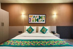 a bedroom with a large white bed with two pillows at Treebo Sky Vista Suites with Hill View in Chikmagalūr