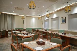 a conference room with tables and chairs and a podium at The Bhavani Hotel in Dāhod