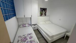 a small room with two beds in it at Noa Apartments in Vlorë