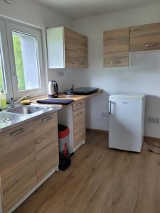 a kitchen with a white refrigerator and wooden cabinets at Bobrowe zacisze in Wleń