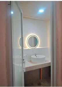a bathroom with a sink and a mirror at Yaga's Stay INN save in Impasugong