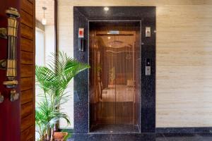 a glass door leading into a building with a plant at Treebo Sky Vista Suites with Hill View in Chikmagalūr