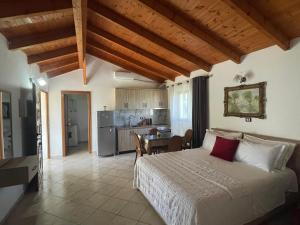 a bedroom with a large bed and a kitchen at Diarla's Home in Fier