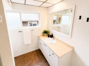 a bathroom with a sink and a mirror at Modern North Van Escape with 2BR BBQ Workspace in North Vancouver +14 photos