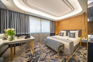 a hotel room with a bed and a desk at Altinel Ankara Hotel & Convention Center in Ankara +68 photos