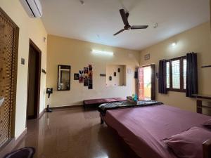 a bedroom with a large bed and a ceiling fan at Geetham Homestay in Tiruchirappalli