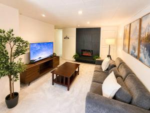 a living room with a couch and a flat screen tv at Modern North Van Escape with 2BR BBQ Workspace in North Vancouver