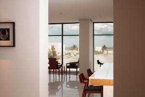 a dining room with a table and chairs and windows at Souq Beach Hotel فندق سوق الشاطئ in Salalah