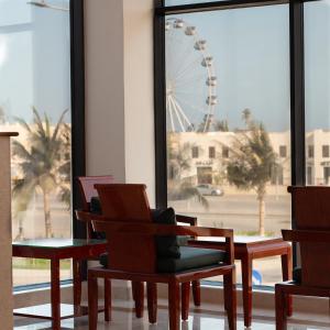 a room with chairs and a ferris wheel in the background at Souq Beach Hotel فندق سوق الشاطئ in Salalah