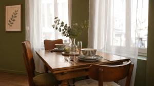 a dining room table with a vase of flowers on it at Oparadi 'L'Authentique' in Wimereux