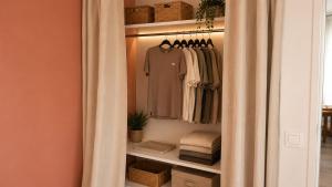 a walk in closet with a curtain and clothes at Oparadi 'L'Authentique' in Wimereux
