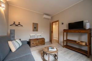 a living room with a couch and a tv and a table at B&B Benvenuto in Venegono Superiore