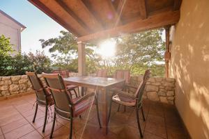 a wooden table and chairs on a patio at House Polic in Hreljin