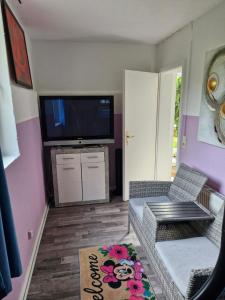 a living room with a couch and a flat screen tv at Apartment 4 nähe Elmshorn Barmstedt in Bokholt-Hanredder