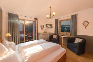 a bedroom with a bed and a chair and a table at Pension Hinterseer in Kitzbühel