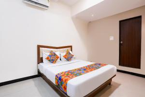 a bedroom with a large bed with colorful pillows at FabHotel SK Galaxy in Thane +27 photos