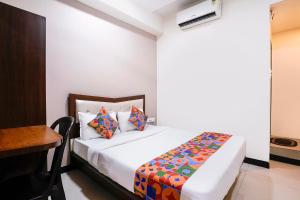 a bedroom with a bed and a desk in a room at FabHotel SK Galaxy in Thane