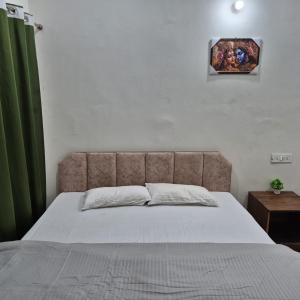 ein Bett in einem Schlafzimmer mit einem grünen Vorhang in der Unterkunft Devadidev Retreat in Gupta Kāshi